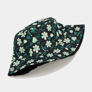 Close-up of the cotton twill texture and light green floral pattern on the black bucket hat