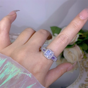 Macro shot of silver ring featuring square clear zircon and purple side gemstones