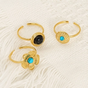 Three-piece vintage gold ring set featuring turquoise and black marble on white knit