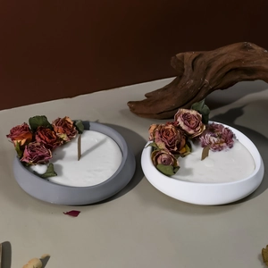 Detalle de recipientes de velas esmerilados con pétalos de rosa secos y mechas de madera