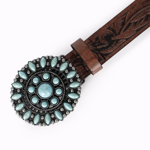 Detail of vintage western belt with embossed leaf patterns and turquoise stone buckle