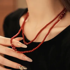 Elegante collana multistrato di perle in vetro rosso con accenti in metallo dorato