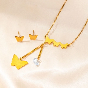 Detail of gold butterfly necklace and stud earrings set with zircon on silk fabric