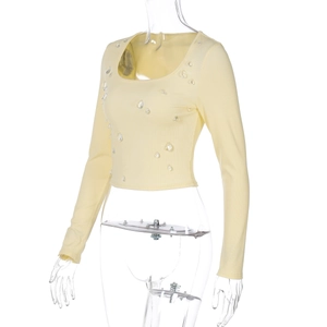 Dettaglio del crop top giallo in maglia a coste con strass a forma di goccia