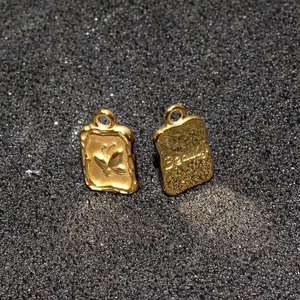 Close-up of golden butterfly pendants with Beauty engraving for DIY jewelry making
