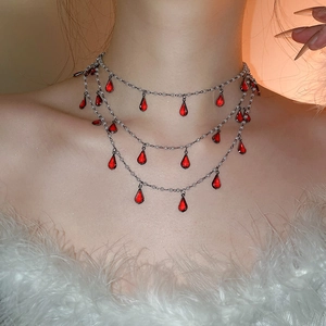 Close-up of triple-layered silver choker with red water-drop gemstones and white pearls