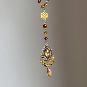 Collier rétro perlé avec nœud chinois et pendentif goutte d'ambre en finition dorée