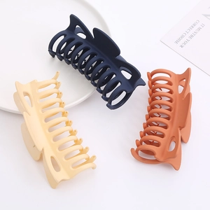 Detailed view of 12cm matte bow claw clips in dark blue, beige, and orange colors