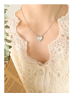 Detail of silver heart necklace with white mother-of-pearl inlay and paperclip chain