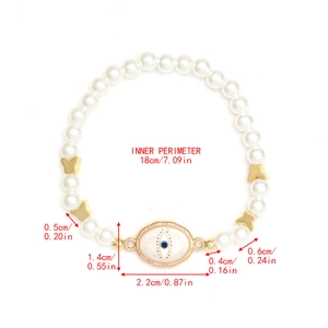 Detail view of pearl beaded evil eye bracelet with dimension measurements and golden charms