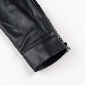 Détail de la manche d'une robe en similicuir noir avec poignets à deux boutons