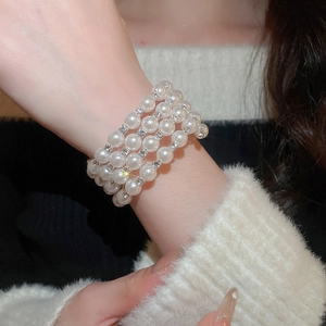 Close-up of a multilayer pearl bracelet with rhinestone spacers on a model's wrist