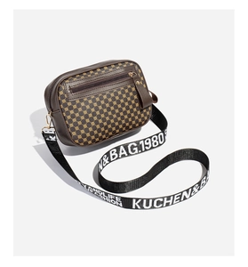 Detail of brown PU leather camera bag with embroidered panels and adjustable logo strap