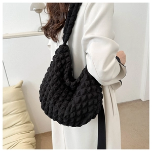 Detail view of black cloud bubble texture tote bag worn on shoulder by a model