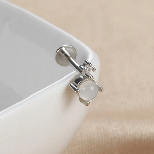 Détail d'un piercing labret en argent S925 avec pierre d'opale et petit cristal brillant