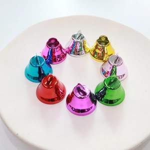 Set of eight 26mm matte colorful metal bells arranged in a circle on a white plate