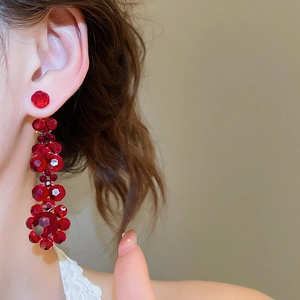 Macro detail of red crystal tassel earrings showing the sparkling multi-faceted beads