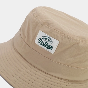 Close-up of khaki quick-dry bucket hat featuring a mountain patch and clean stitching