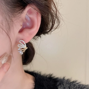 Close-up of elegant gold butterfly earrings featuring sparkling zircon pave settings