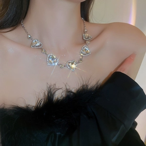 Detail einer silbernen Herz-Halskette mit funkelnden Diamanten an einem Model