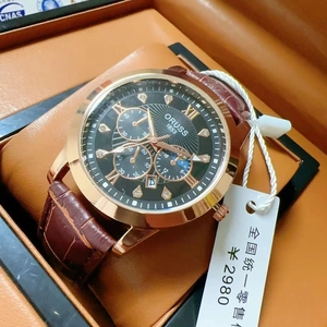 Close-up of gold steel watch with brown leather strap and diamond markers in a gift box