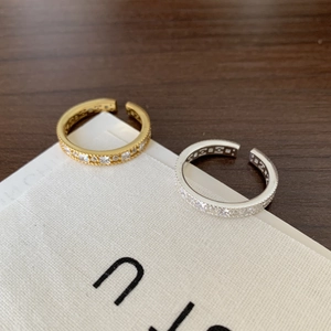 Macro detail of gold and silver open rings featuring micro-pave zircon stones and bead edges