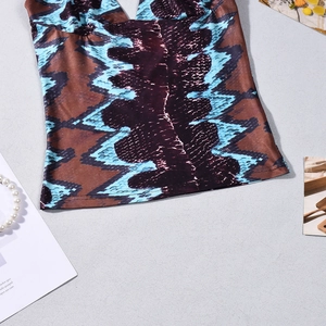Detailed view of snake print halter top featuring sheer mesh and deep V-neckline texture