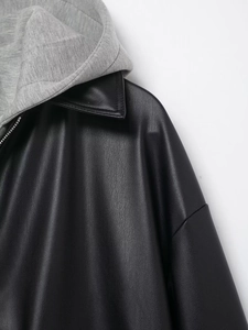 Close-up of leather jacket with grey knit hood detail and metallic zipper closure