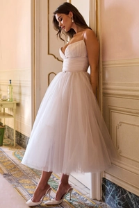 Detail of elegant white mesh strap dress with layered tulle and backless V-neck design