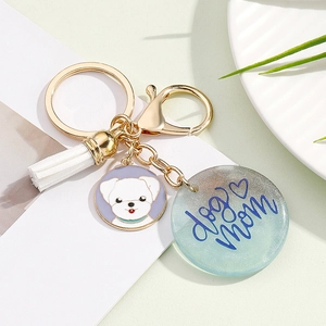 Detail of 'dog mom' resin pendant with white tassel and cartoon dog charm keychain