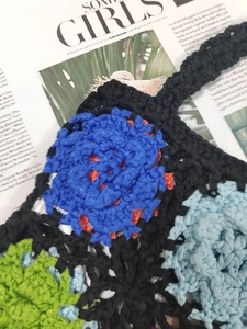 Close-up of handmade crochet bag showing floral patterns and intricate knit texture