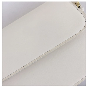 Close-up of white leather handbag showing meticulous stitching and smooth PU texture