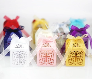Laser-cut wedding favor boxes with cross motif and ribbon in multiple colors