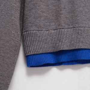 Women's crewneck knit cardigan featuring layered grey and royal blue ribbed hem detail