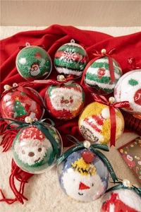 Close-up of fluffy coral fleece Christmas socks with festive embroidery in gift ball packaging