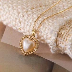Elegant 18K gold-plated copper necklace featuring a heart pearl pendant on knit fabric