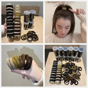Elastic seamless hair ties set in earth tones with a clear storage tube and stand