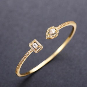 Macro detail of gold-plated brass cuff bracelet featuring drop and rectangle zircon stones