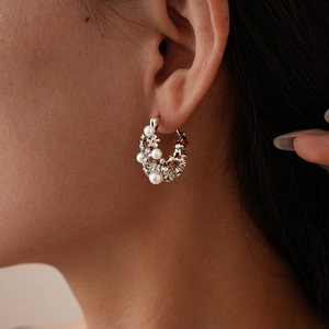 Macro shot of vintage silver flower basket hoop earrings with pearls and crystals