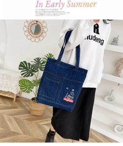 Dettaglio della borsa tote in denim blu con tasche anteriori e stampa personalizzata con stella