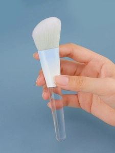Detail of angled makeup brush with blue gradient ferrule and clear acrylic handle