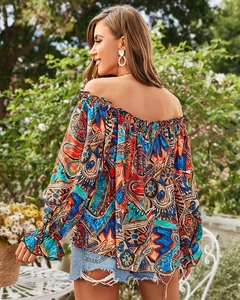Detail of vintage floral off-shoulder blouse with ruffled cuffs in a sunny garden