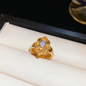 Detail of 24K gold plated flower ring with white zircon pave setting in a jewelry box