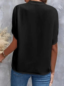 Rear view of women's black short sleeve shirt featuring silky texture and loose fit