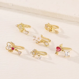 Detailed view of six gold non-piercing nose clips with heart-shaped colorful zircons