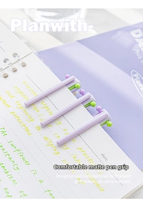 Detail of matte triangular aesthetic pens on a notebook with colorful button ends