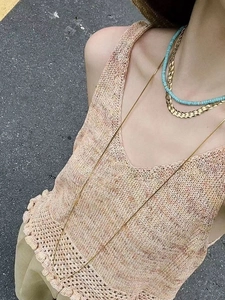 Macro view of layered gold snake chain necklace with turquoise bead necklace detail