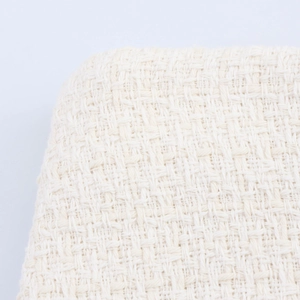 Close-up macro of white tweed fabric texture with detailed woven cotton blend pattern