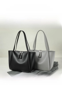 Detail view of large tote bags in black and gray soft leather with dual zipper closure