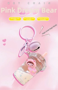 Macro shot of pink cartoon bear doll in liquid glitter keychain with metal bell